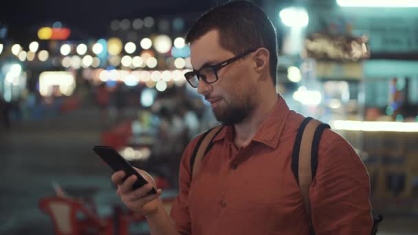 Mann mit Smartphone in nächtlicher Stadt — Stockvideo