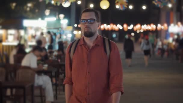 Solo hombre turista es descansando en asiático ciudad en la noche — Vídeo de stock