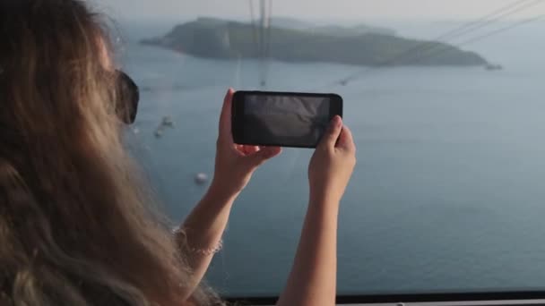 Femme capturant des paysages marins depuis un téléphérique à Phu Quoc, Vietnam — Video