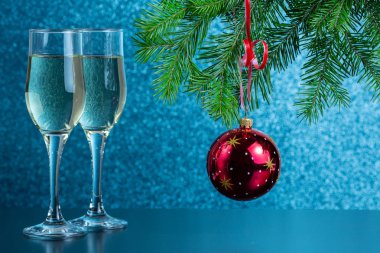 Masanın üzerinde iki kadeh şampanya ve yeni yıl oyuncakları var.