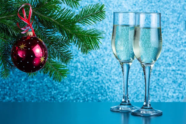 Masanın üzerinde iki kadeh şampanya ve yeni yıl oyuncakları var.