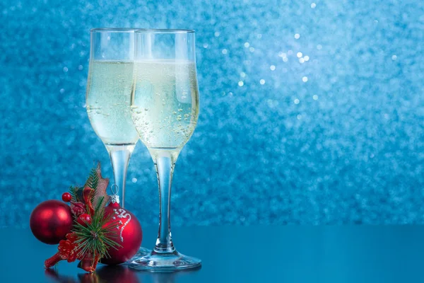 Masanın üzerinde iki kadeh şampanya ve yeni yıl oyuncakları var.