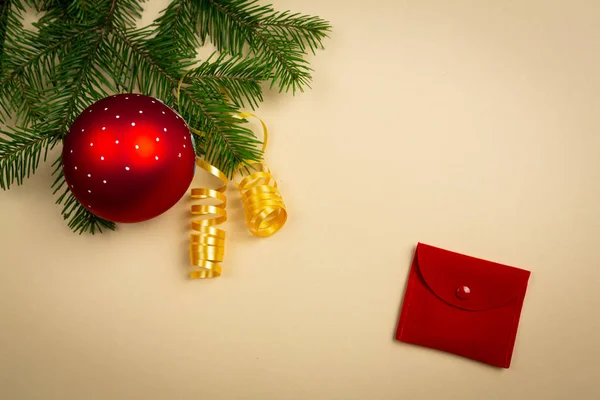 Üniformalı bir arka planda ladin dalları ve yeni yıl oyuncakları uzanıyor.