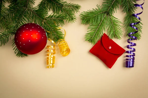 Üniformalı bir arka planda ladin dalları ve yeni yıl oyuncakları uzanıyor.