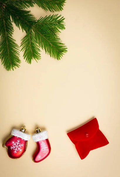 Üniformalı bir arka planda ladin dalları ve yeni yıl oyuncakları uzanıyor.