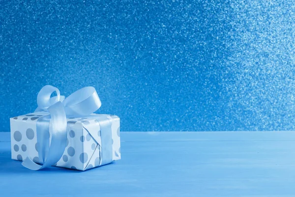 Mavi bir masada hediye kutusunda bir kutu var. Hediye, sürpriz, yeni yıl hediyesi.,