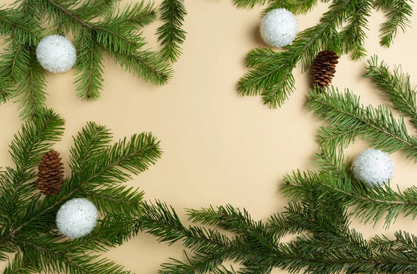 Üniformalı arka planda ladin dalları, Noel oyuncakları ve koniler