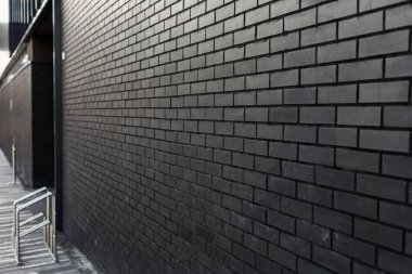 Lacivert arka planı olan siyah tuğladan bir duvar. Boşluğu kopyala