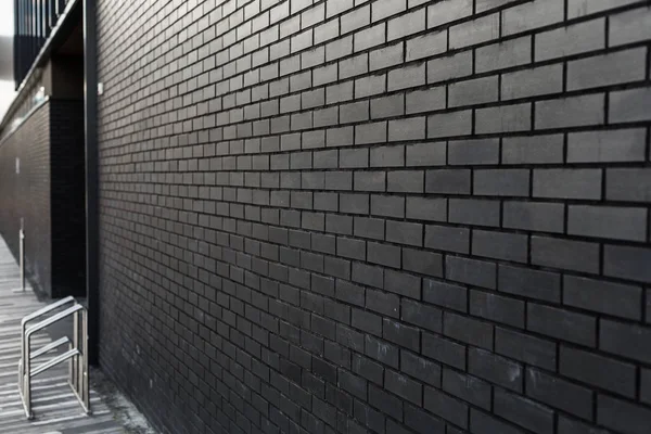 Lacivert arka planı olan siyah tuğladan bir duvar. Boşluğu kopyala