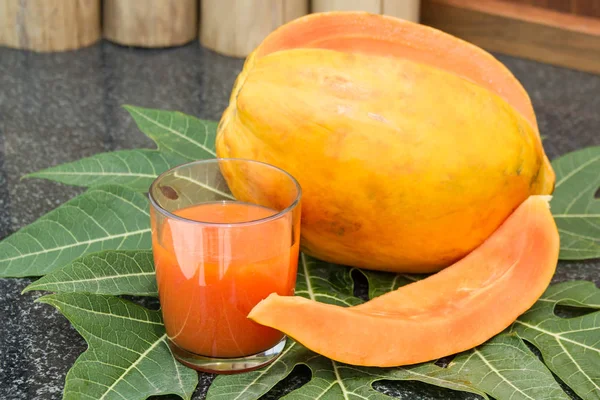 Fresh papaya juice in the glass with papaya fruits, leaf and slices — Stock Photo, Image