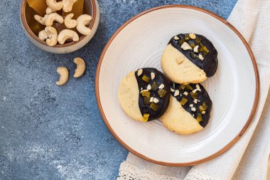 Açık bej arka planda ev yapımı vanilyalı çikolatalı kaju kurabiyesi ve mango reçeli. Doğal tatlılar. Sıcak çay partisi konsepti