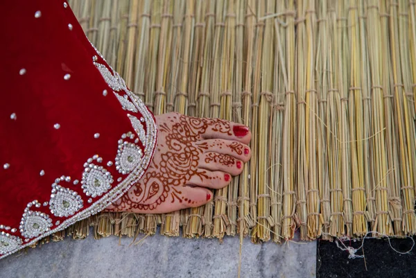 Boda tradicional india. auténtico ritual védico de boda llamado vivaha Yajna. Sari rojo, pies de mujer con mehendi de cerca. guirnaldas de flores. Ritual del fuego sagrado. pareja multinacional . — Foto de Stock