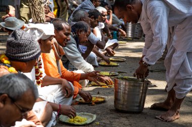 Shantipur, Batı Bengal, Hindistan - 7 Mart 2020. Hint halkı Santipur Festivali sırasında geleneksel Hint yemeği khichdi prasadam yiyor. Hindistan 'da bedava yiyecek dağıtımı