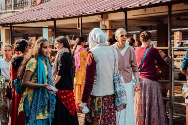 Mayapur, Batı Bengal, Hindistan - 7 Şubat 2020. Çok uluslu bir grup genç kız Hint inek çiftliğine geziye çıktı. Çocuklar kutsal Hint inekleri zebu ile ilgilenir. Yaşam tarzı