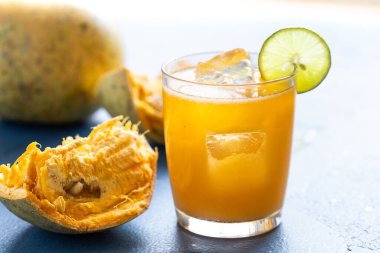 Hindistan 'da Bel Ka Sharbat denilen Bel meyvesi veya ahşap elmadan egzotik meyve suyu. Buzlu, limonlu ve mavi arka planda Bel meyveli soğuk meyve suyu. Doğal detoks. Bağışıklık için vitaminler.