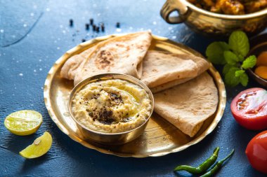 Doğu yemekleri - Hint paneer sabji chapati ve soslu. Hint mutfağı. Bakır pirinçten Hint körisi, mavi arka planda malzemeler, yakın plan Hint yemeği seti.