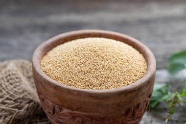 Rustik ahşap arka planda Amaranth bitkisinin olduğu bir kasede çiğ organik Amaranth Grain. Sağlıklı renkli glüten besin konsepti.
