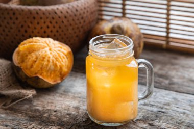 Hindistan 'da Bel Ka Sharbat denilen Bel meyvesi veya ahşap elmadan egzotik meyve suyu. Buzlu soğuk meyve suyu ve ahşap arka planda Bel meyvesi dilimleri. Doğal detoks. Bağışıklık için vitaminler.