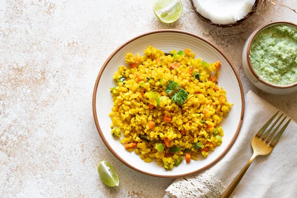 Indian cuisine Indian food. Indian cuisine. Poha or flattened rice traditional Western Indian breakfast with coconut chutney sauce curry leaves. national authentic vegetarian Asian food. top view