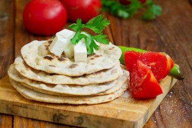 Ev yapımı düz ekmek, domatesli ve peynirli tortilla, köy usulü.