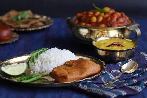 traditional Indian home-cooked dinner. dishes of national Indian cuisine on a dark blue background. rice, dal, sabji, aloo parantha, gulabjamun, masala
