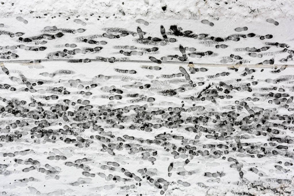Footprints in the Snow. Sidewalk covered with snow with traces of shoes in the winter.