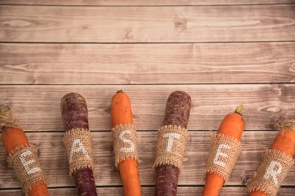 Easter carrots on a wooden background in rustic style — Stock Photo, Image