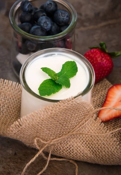 Yogur casero, crema agria con arándanos y fresas sobre fondo de pizarra de piedra . —  Fotos de Stock