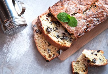 Pudra şekeri ve nane ile serpilir üzümlü geleneksel kek dekore edilmiş bırakır. Mermer gri arka plan