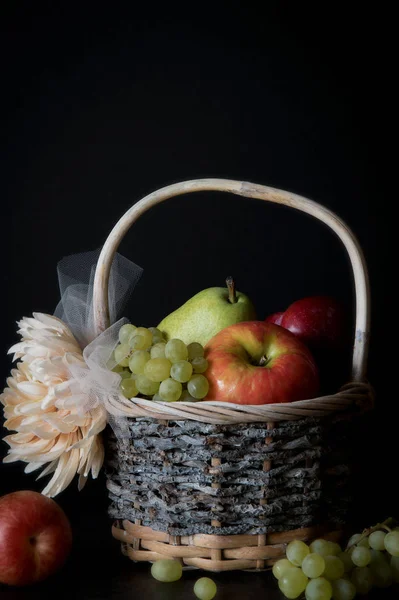 Surtido de frutas frescas crudas en canasta de mimbre sobre fondo negro. Con espacio de copia — Foto de Stock