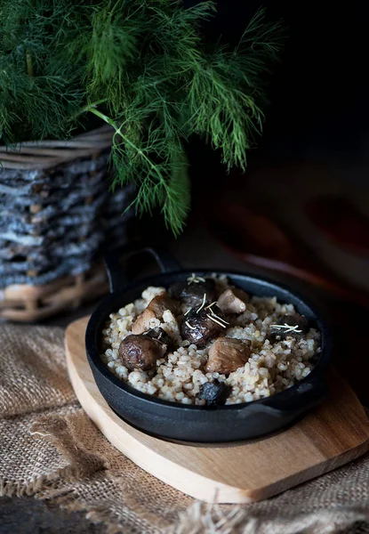 Porridge d'orzo con funghi di foresta e carne in ghisa . — Foto Stock