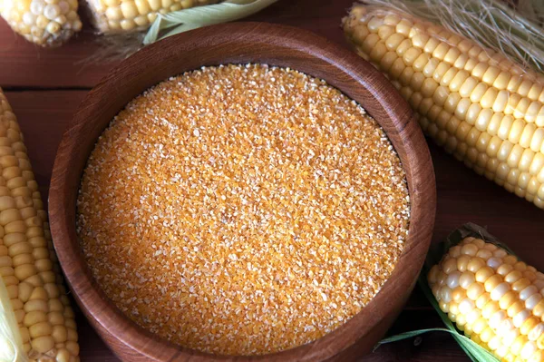 Corn grits on a wooden background