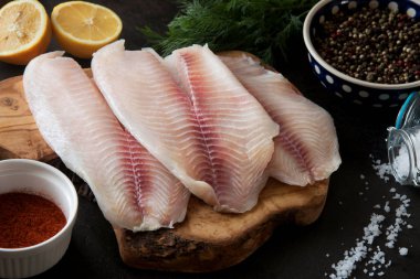 Taze balık fileto pişirme ve baharat doğrama tahtası üzerinde malzemelerle