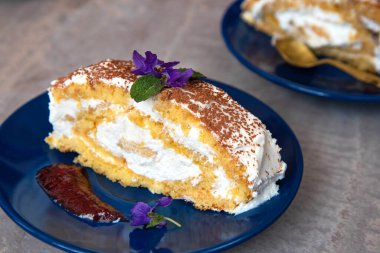 Kremalı İsviçre dürümü, tabakta bir parça ev yapımı kek..