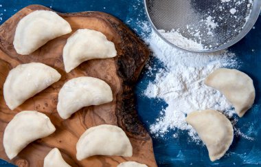 Çiğ köfte ve patates. Tahta üzerinde hazır hamur tatlısı. Çiğ Varenyky.