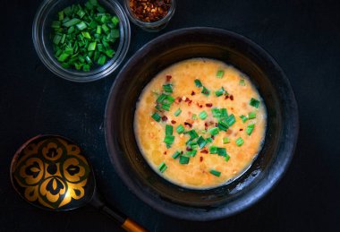 Yeşil soğan serpilmiş sebzeli peynir çorbası.