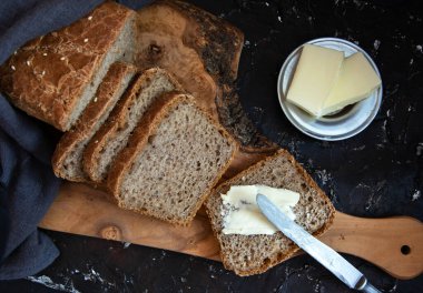 Tohumlu ev yapımı tahıllı ekmek. Tereyağlı bir parça ekmek. Üst görünüm.