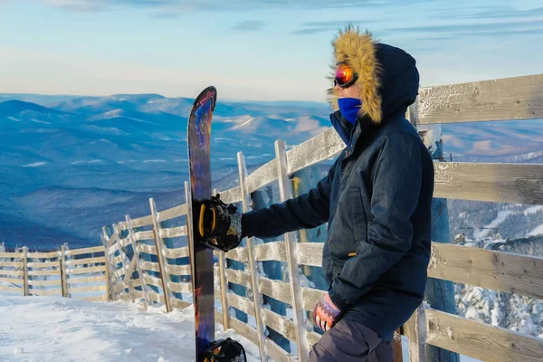 Joven exitoso haciendo snowboard en las montañas Sheregesh. Snowboarder descansando en la cima de la montaña. snowboarder caucásico sobre un fondo del cielo. La reunión de empresarios en Teambuilding Snowboard. —  Fotos de Stock