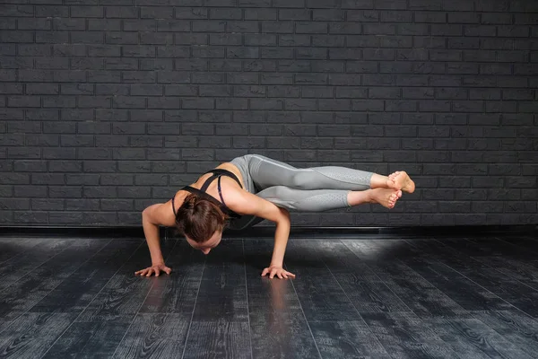Yoga - Asana ellerde, parshva bakasana hazır. Sağlıklı bir yaşam tarzı. Kız meditasyon yoga sınıfındaki pratiği yapıyor. Gevşeme ve germe.
