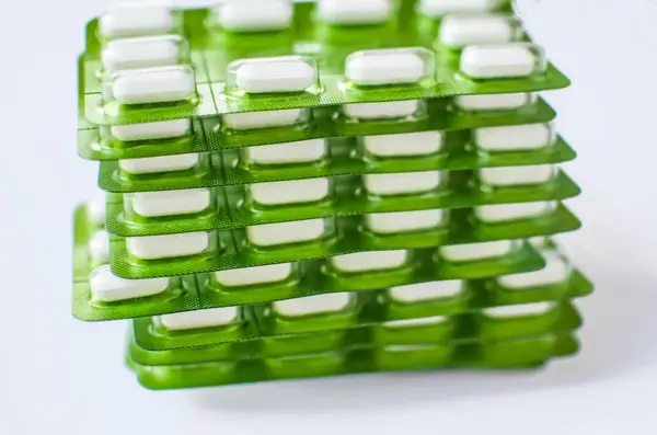 Comprimidos blancos en blíster verde, enfoque suave — Foto de Stock