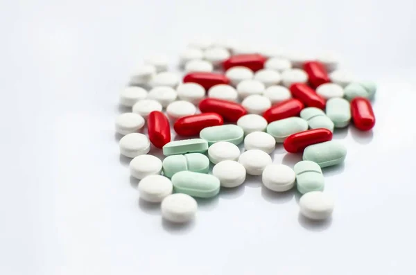 Červená/bílá/zelená pilulky léku na bílém pozadí — Stock fotografie