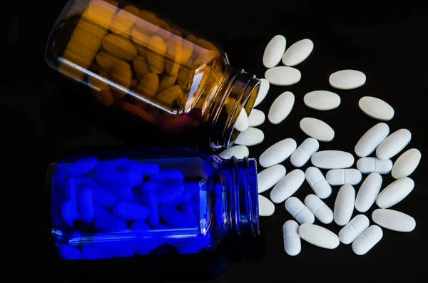 Pills medicine in bottle & antibiotics on black background — Stock Photo, Image