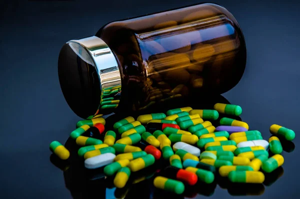 Prášky na medicínu v láhvi & antibiotik na černém pozadí — Stock fotografie