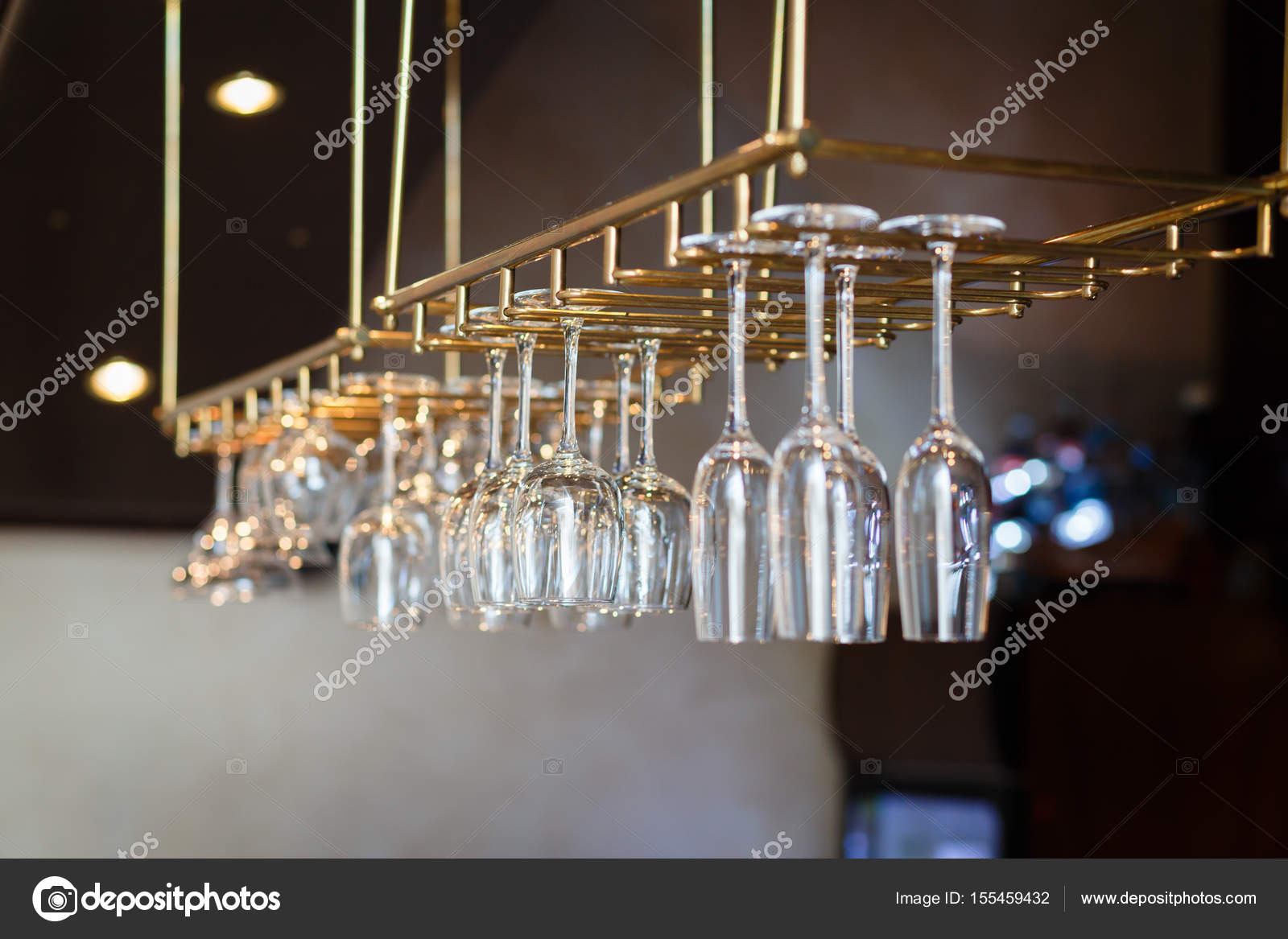 Glasses hanging over a bar rack,Cocktail glasses hanging over a bar