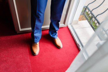 Pahalı ayakkabı kahverengi erkek portre kırmızı halı üzerinde mavi pantolon.