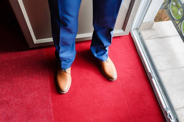 Pahalı ayakkabı kahverengi erkek portre kırmızı halı üzerinde mavi pantolon.