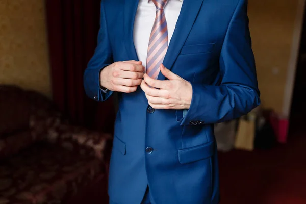 Hombre de traje azul dos botones, haciendo botón. Elegante hombre de negocios en un hotel caro, yendo a una reunión — Foto de Stock