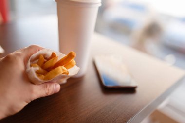 Erkek eli restaur bir beyaz karton kutuda patates kızartması holding