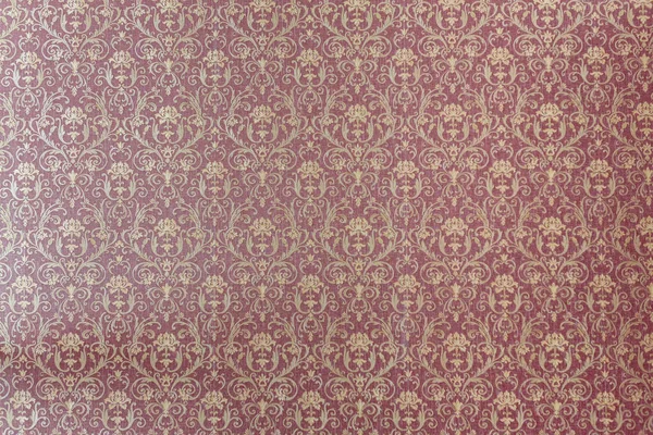 Patterned red wallpaper in the expensive interior. A lush red sofa pattern of swirls. Can be used as a background.