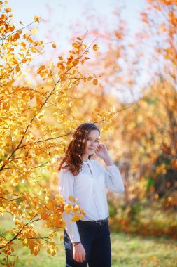 Young beautiful woman. Beauty smiling teenager girl in autumn park
